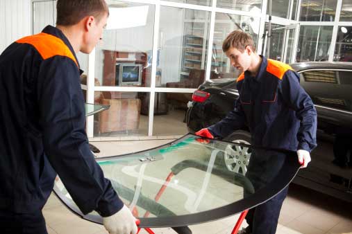 technicians carefully moving auto glass