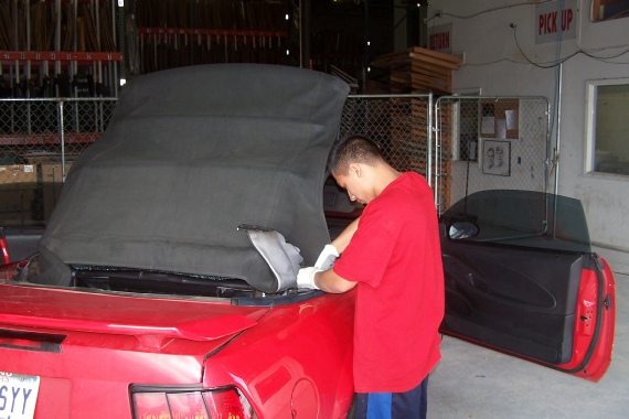 man replacing car convertible top